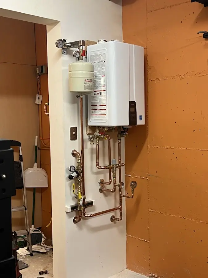 Plumbing technician inspecting water heater connections in Hailey